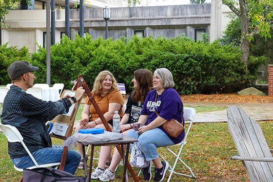 Photo of a group of Chatham University students pose together after doing yard work together during a volunteer day